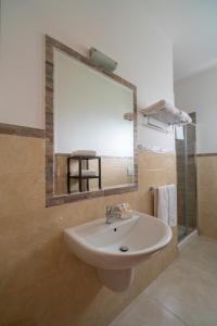 a bathroom with a sink and a large mirror at Villaggio Passo Dell'Arciprete in Vieste