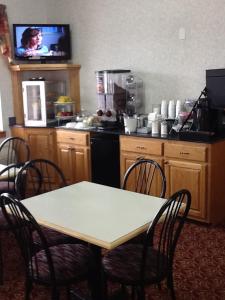 a kitchen with a table and chairs and a television at Americas Best Value Inn - Brookhaven in Brookhaven