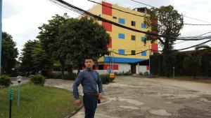 a man is standing in front of a building at Sentosa Hotel & Restaurant - tersertifikasi CHSE dari Kementerian Pariwisata dan Ekonomi Kreatif in Bekasi