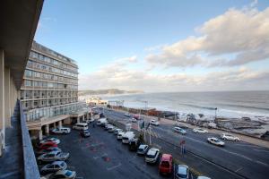 een parkeerplaats naast een strand met geparkeerde auto's bij Kennaway Hotel in East London