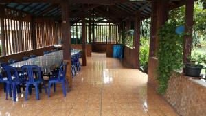 a patio with a long table and blue chairs at Sentosa Hotel & Restaurant Bekasi in Bekasi
