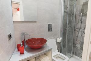 un bagno con un lavandino rosso e una doccia di Napoli Capitale a Napoli Altre 31 foto