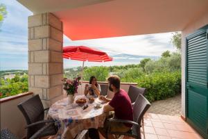 a man and woman sitting at a table on a patio at Villaggio Passo Dell'Arciprete in Vieste
