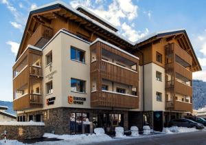 ein großes Gebäude mit Schnee davor in der Unterkunft Hotel Garni Alpenjuwel Residenz in Serfaus