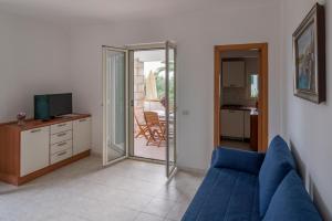 a living room with a blue couch and a television at Villaggio Passo Dell'Arciprete in Vieste