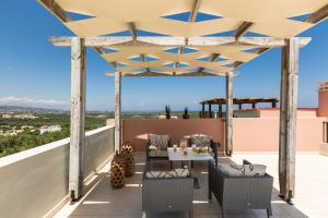 een patio met een tafel en stoelen op een dak bij Cretan Royalty in Loutra