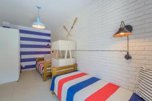 1 Schlafzimmer mit 2 Betten und Ziegelwand in der Unterkunft Apartamenty NCNK Baltic Park MEDIUM w Stegnie - 500 m do plaży in Stegna