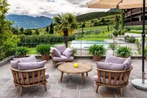 een patio met stoelen, een tafel en een zwembad bij Die Sonne in Kaltern in Caldaro