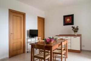 a dining room with a table and chairs and a television at Villaggio Passo Dell'Arciprete in Vieste