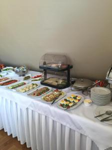 stół z wieloma talerzami jedzenia w obiekcie Hotel Maxim Kwidzyn w mieście Kwidzyn