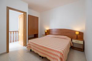 a bedroom with a bed with a orange and white blanket at Villaggio Passo Dell'Arciprete in Vieste