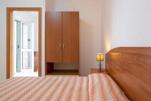 a bedroom with a bed and a cabinet and a lamp at Villaggio Passo Dell'Arciprete in Vieste