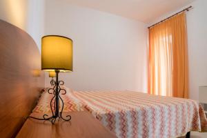 a bedroom with a bed and a lamp on a table at Villaggio Passo Dell'Arciprete in Vieste