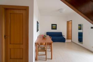 a living room with a table and a blue couch at Villaggio Passo Dell'Arciprete in Vieste