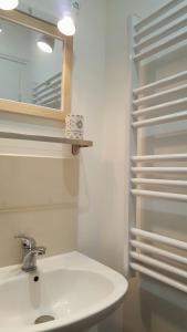 チュールにあるAppart Confortable à Tulle - Bien situé - Calmeのバスルーム(白い洗面台、鏡付)