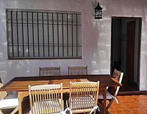 a wooden table and chairs in a room at Precioso duplex con piscina in Chiclana de la Frontera