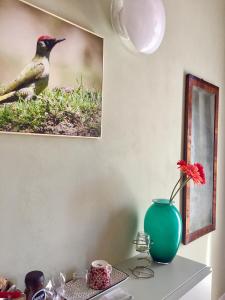 a table with a vase and a picture of a bird at Bio-Agriturismo Carpareto in San Miniato