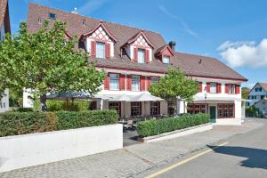 ein großes rotweißes Gebäude auf einer Straße in der Unterkunft Hotel-Restaurant Löwen in Dielsdorf