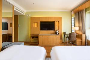 a hotel room with two beds and a flat screen tv at Baymond Hotel in Busan