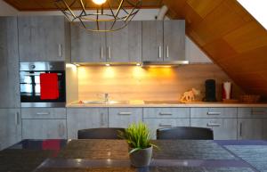 a kitchen with gray cabinets and a table with chairs at Ferien-Apartment im Genusshotel Hirschen (Südschwarzwald) in Kleines Wiesental