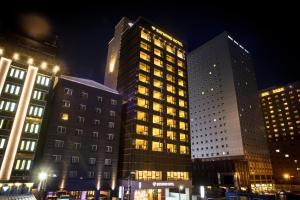 two tall buildings in a city at night at Baymond Hotel in Busan