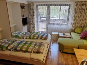 a living room with two beds and a couch at B3 Albmatte-FEWO Sauna, Hallenbad Außenbecken Massagen nebenan in Menzenschwand