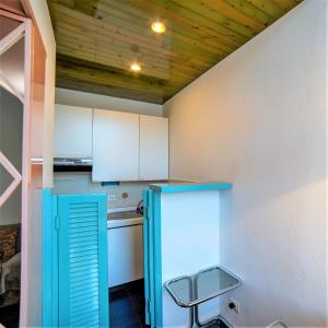 a kitchen with a blue refrigerator and a chair at La Finestra sul Mare in Portovenere