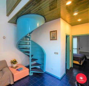 a blue spiral staircase in a living room with a couch at La Finestra sul Mare in Portovenere