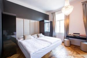a bedroom with a large white bed and a black wall at Sophie's Hostel in Prague