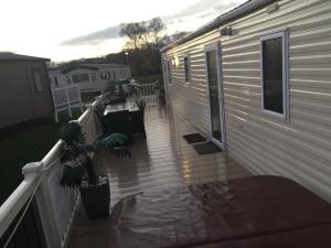 a porch of a house with a deck at 3 bedroom 8 berth Standard Basic caravans with Hot Tub,Mountain Bikes in Tattershall