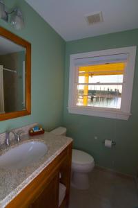a bathroom with a sink, toilet and window at Edgewater Inn - St. Augustine in Saint Augustine