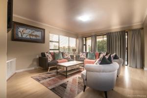 a living room with two couches and a table at Atlantic Bay Lodge in Cape Town