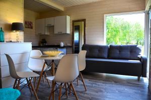 a living room with a couch and a table and chairs at Noclegi Beata in Dąbki