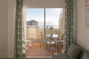 Cette chambre dispose d'une table et d'un balcon avec vue. dans l'établissement Estudio Apartamento Nuevo Benalbeach, à Benalmádena
