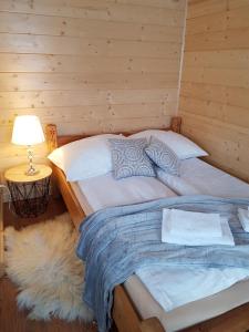 Antonówka في Trybsz: سرير كبير في غرفة خشبية مع مصباح