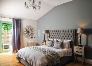 a bedroom with a large bed and a chandelier at The Wyvill Arms in Leyburn