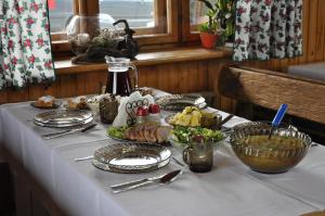 a table with a white table cloth with food on it at Antonówka in Trybsz