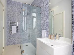 a bathroom with a sink and a glass shower at Porto Downtown Lovers Suites: Bombarda 451 in Porto