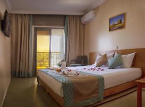 a hotel room with a large bed with a balcony at Hotel Al Mamoun in Inezgane