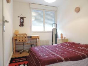 1 dormitorio con cama, escritorio y silla en Superbe maison, confort calme et pratique, en Cergy