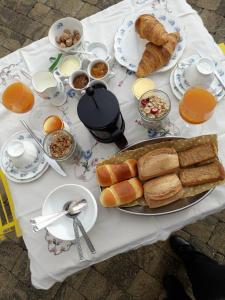 una mesa con un plato de pan y pasteles. en La fermette, en Tréméoc