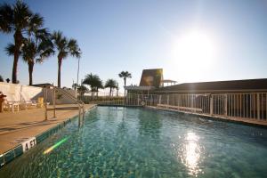 uma grande piscina com palmeiras e um edifício em Edgewater Inn - St. Augustine em Saint Augustine