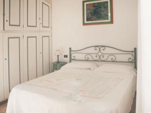 1 dormitorio con cama blanca y colcha blanca en Villa Dea by Interhome, en Forte dei Marmi