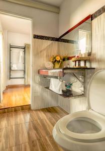 a bathroom with a toilet and a mirror at Hotela Boutique Resort in Suphan Buri