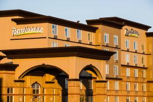 a large building with an archway in front of it at Radisson Hotel & Suites Fort McMurray in Fort McMurray