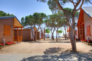 a row of houses in a village with a tree at Camping Bon Repós in Santa Susanna