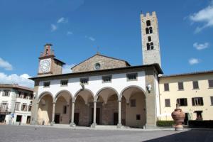 un bâtiment avec une tour d'horloge en haut dans l'établissement La Suite dei Ricordi, à Impruneta