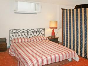 1 dormitorio con 1 cama con colcha a rayas y lámpara en Villa Marzia by Interhome, en Forte dei Marmi
