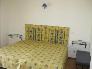 een slaapkamer met een bed met een gele sprei bij Hotel Minho Belo in Vila Nova de Cerveira