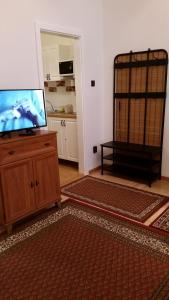 a living room with a flat screen tv on a dresser at Apartment in the "antique street" in Budapest